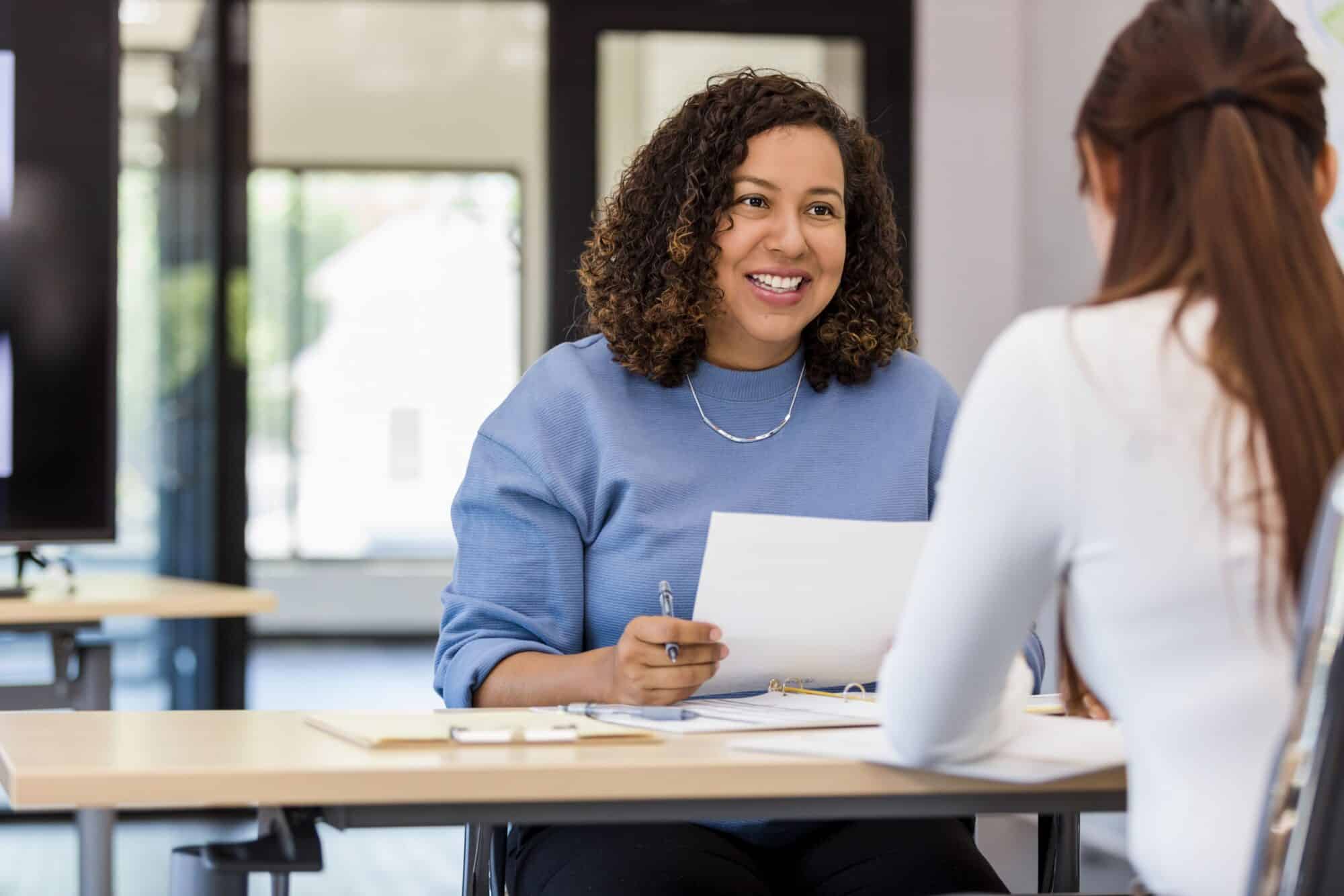 Two women discuss marketing topics across a table.