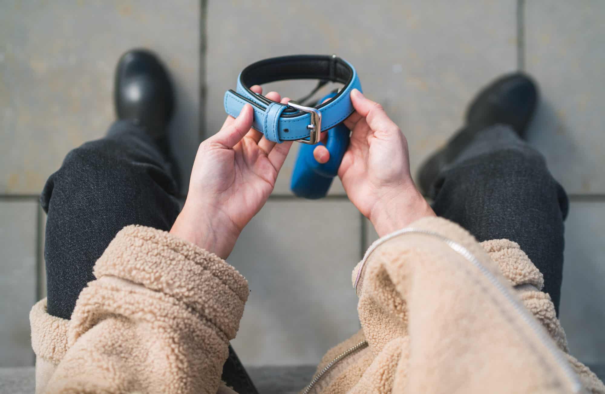 A grieving pet owner holds their pet's collar.