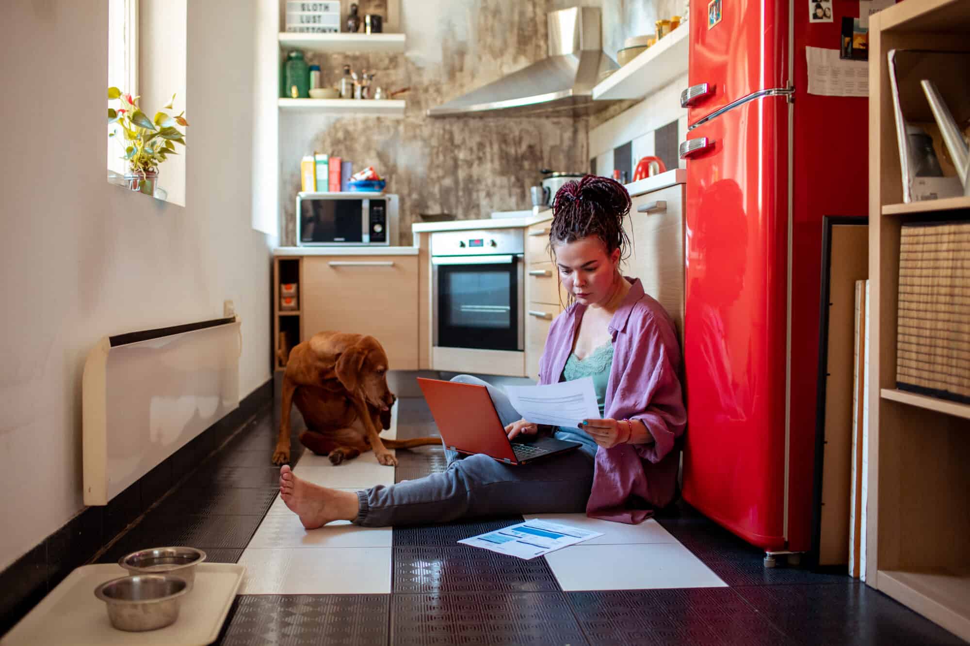 A woman working on her budget with her dog.