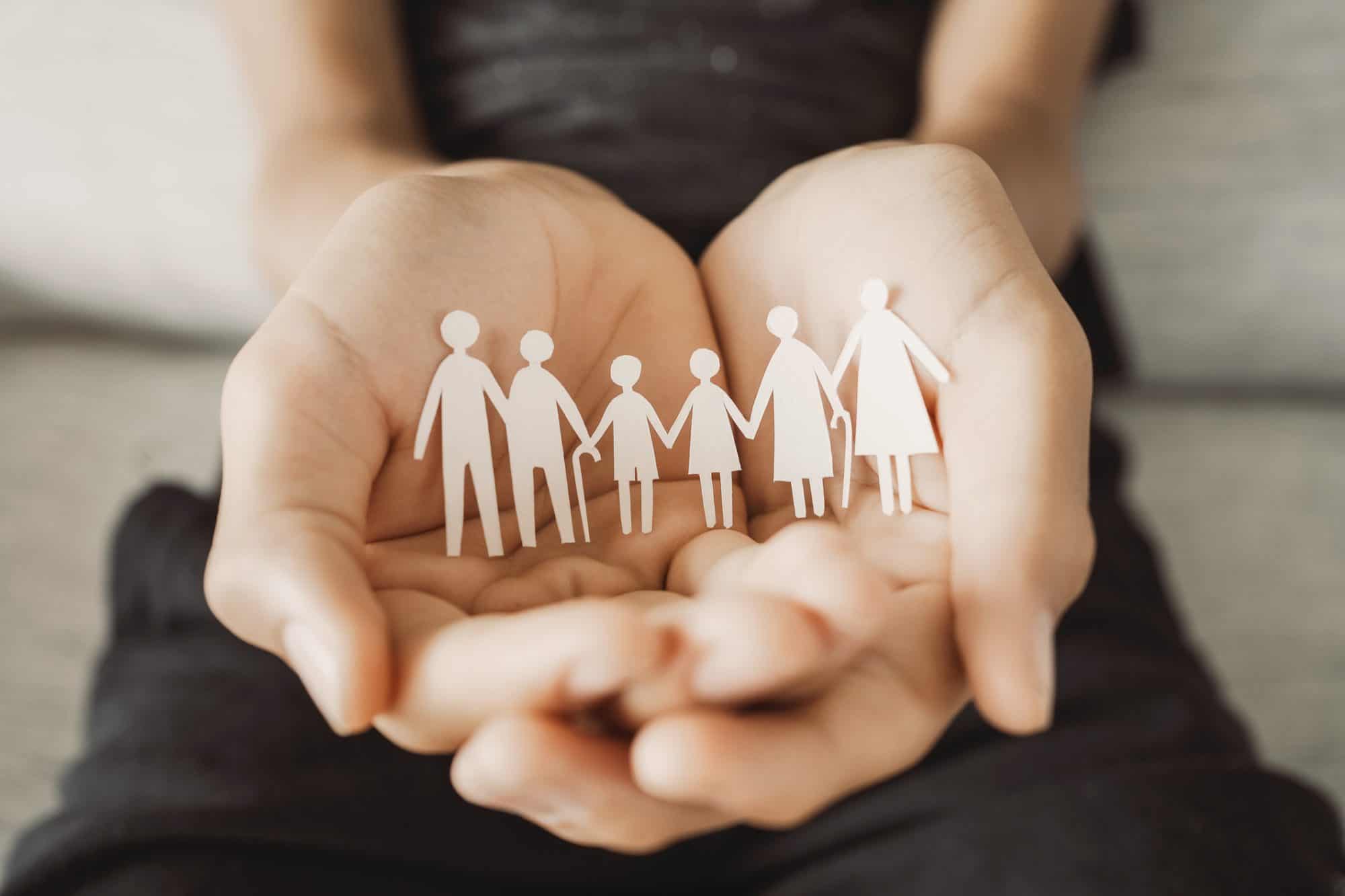 A woman holding paper cutouts of people.