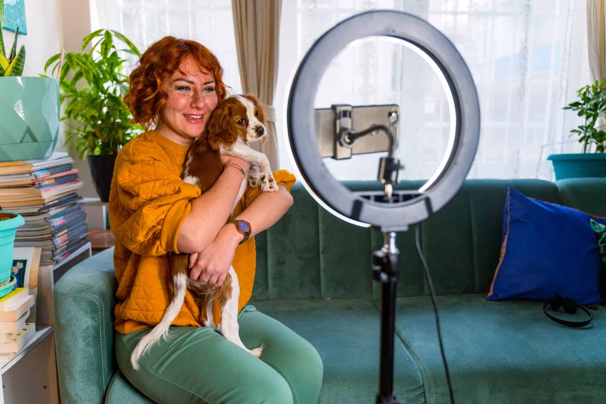 A woman making a video with her dog.