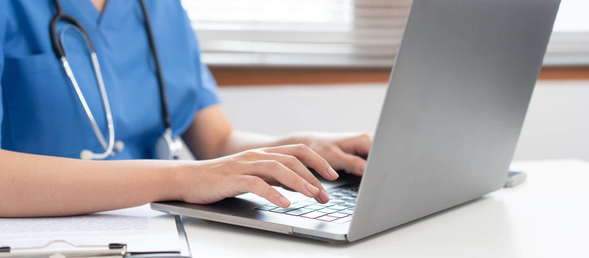 A veterinary staff member using a laptop.